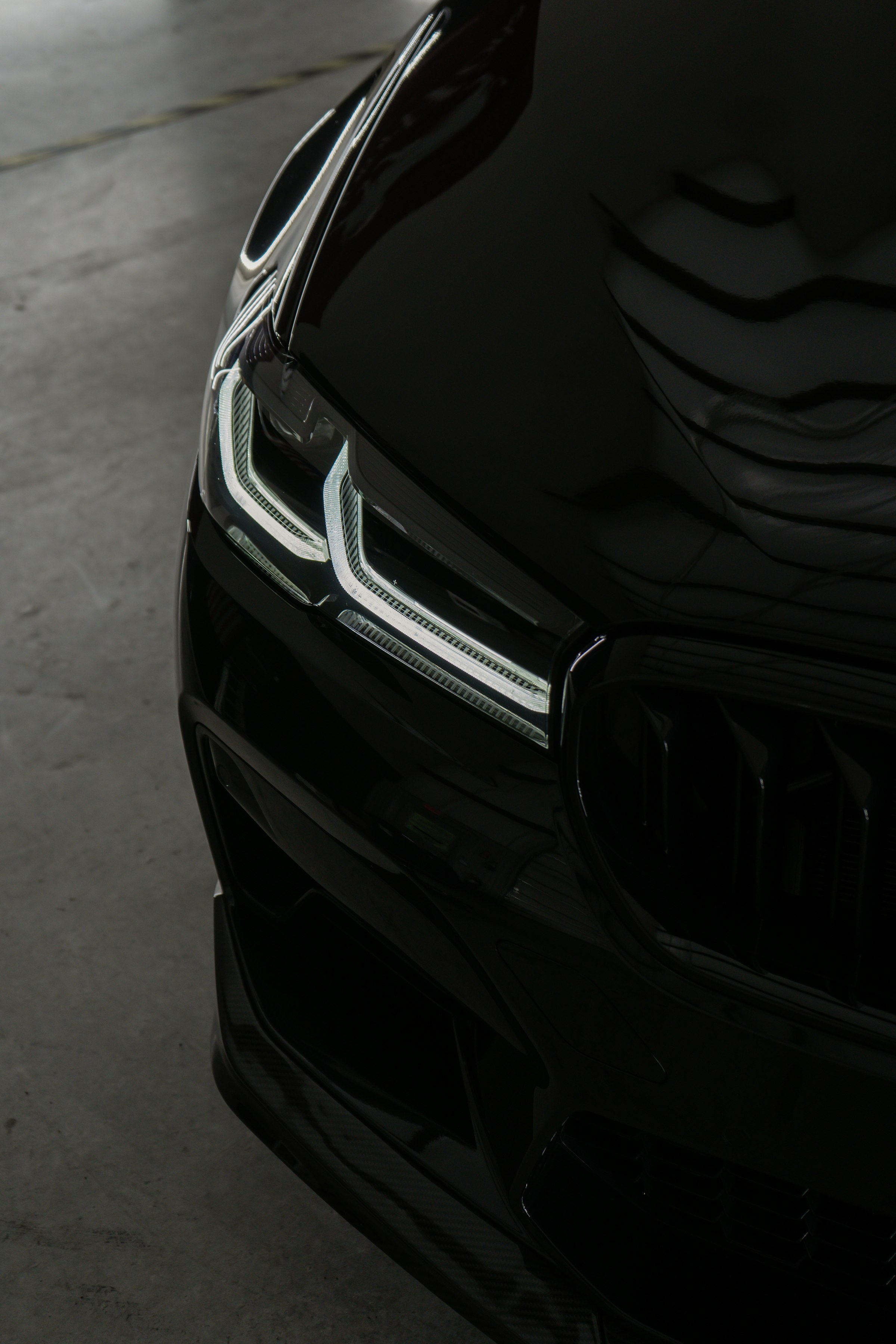 Glossy black car bonnet with a microfiber cloth, mid-detail
