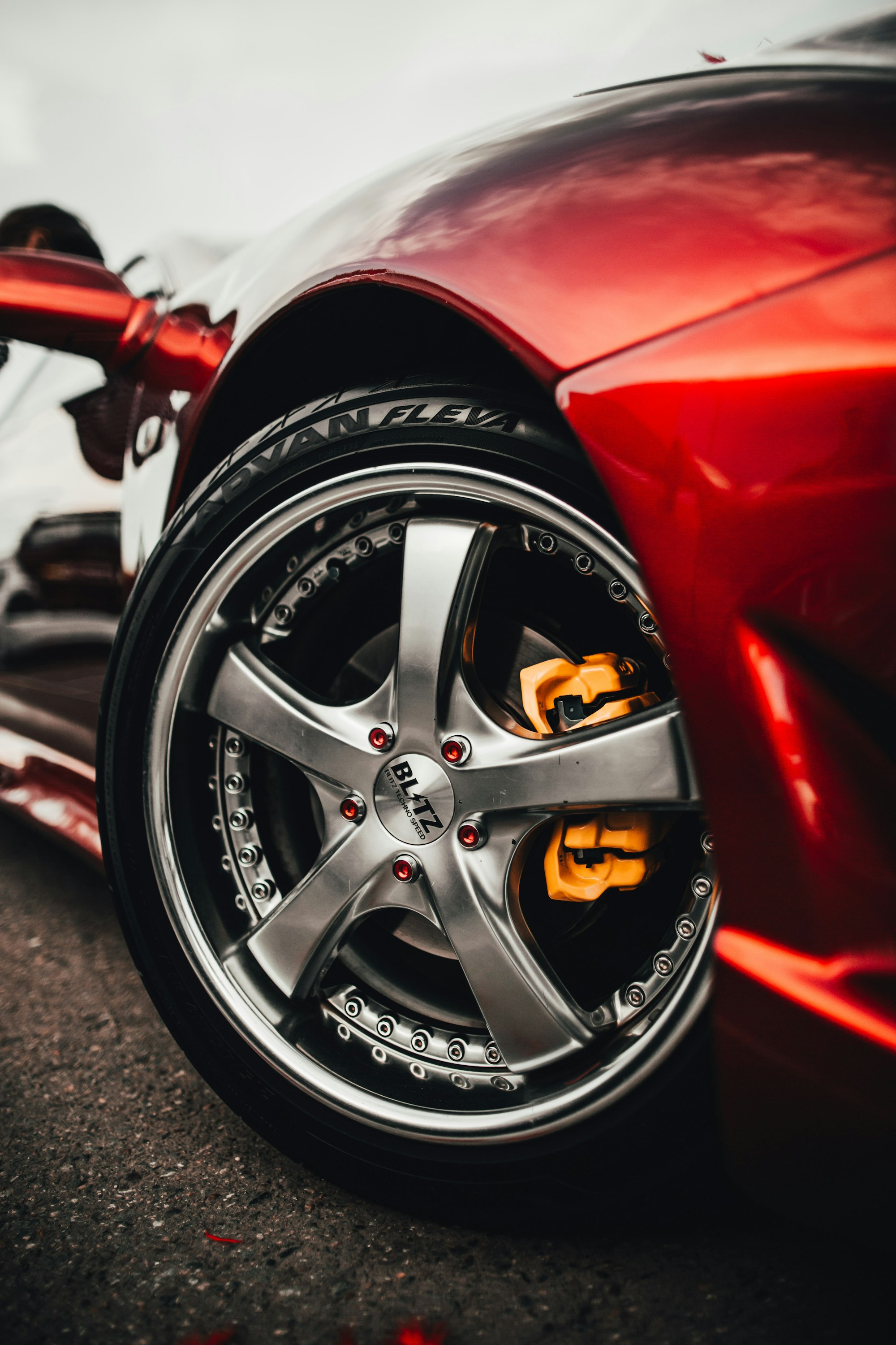 Detailed red sports car wheel and bodywork close-up