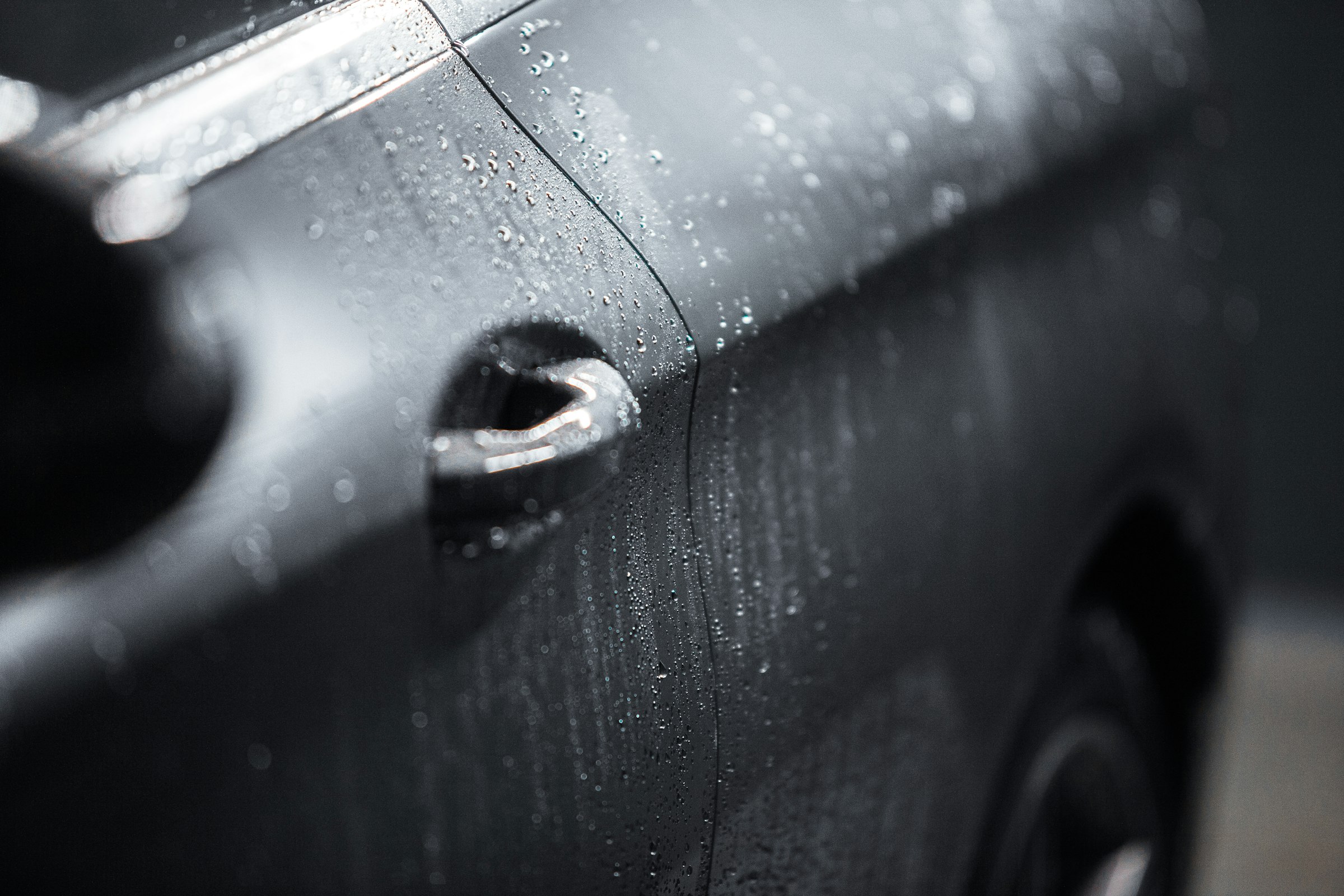 Water beading on a freshly washed dark car panel